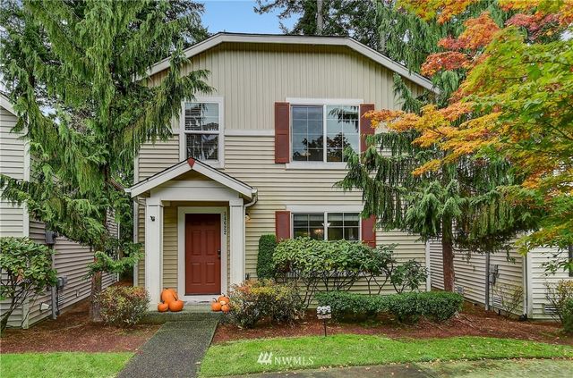 front view of a house with a yard and an trees
