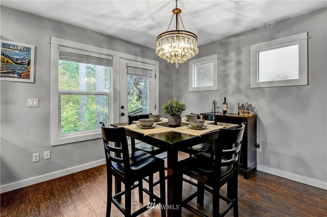 a view of a dining room with furniture a chandelier and wooden floor