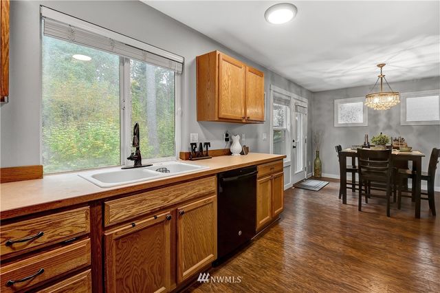 a kitchen with stainless steel appliances granite countertop sink stove and wooden cabinets