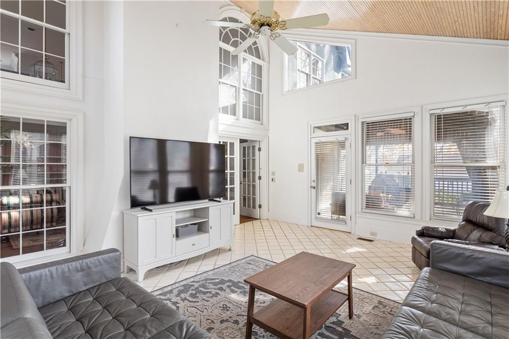 3910 Spalding Bluff Drive Peachtree Corners, GA 30092 - Photo 6 of 35 a living room with furniture a flat screen tv and a floor to ceiling window