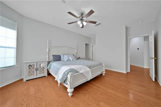 a bedroom with a large bed and a ceiling fan