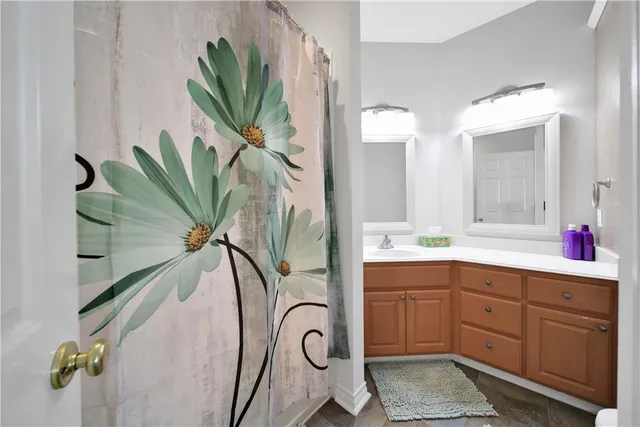a bathroom with a sink a mirror and a potted plant