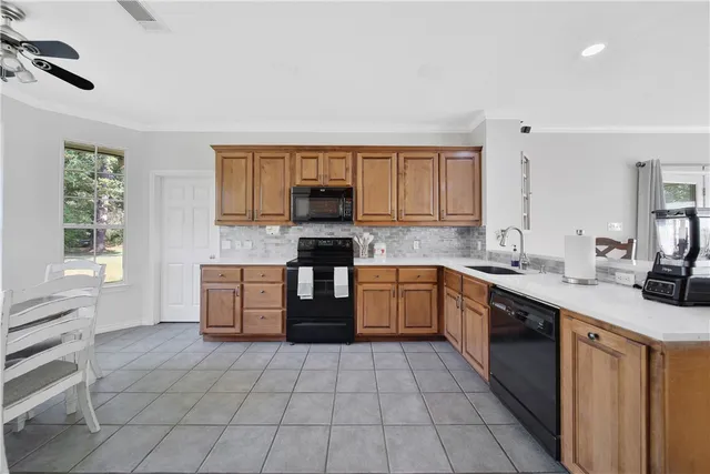 a kitchen with a sink a stove cabinets and a window