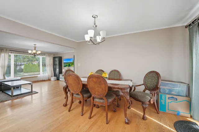 a dining room with furniture a chandelier and wooden floor