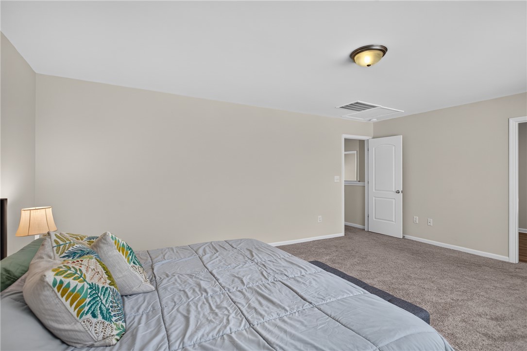 1081 Edenbrooke Circle Anderson, SC 29621 - Photo 24 of 46 A well-lit bedroom with ample space, featuring soft carpeting and a clear passageway to an adjoining room.
