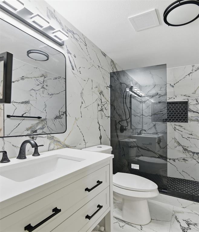 6646 East Lovers Lane, Unit 1201 Dallas, TX 75214 - Photo 16 of 24 a bathroom with a sink toilet vanity and shower