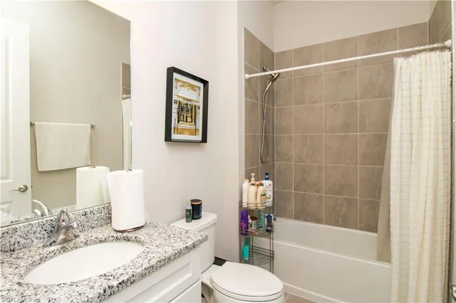 a bathroom with a granite countertop toilet sink and bathtub