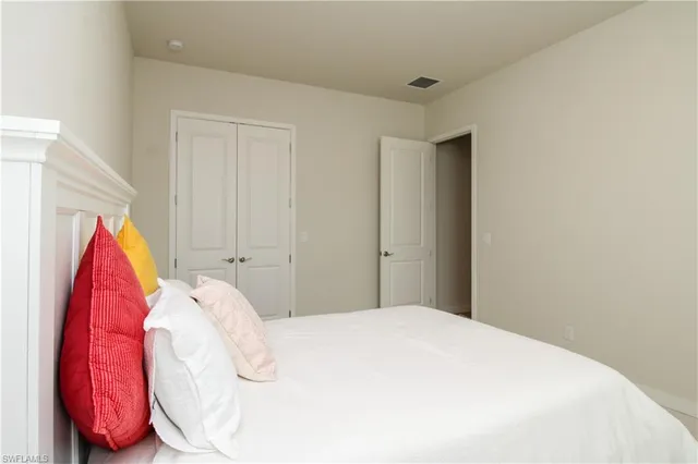 a bedroom with a white bed and a chair