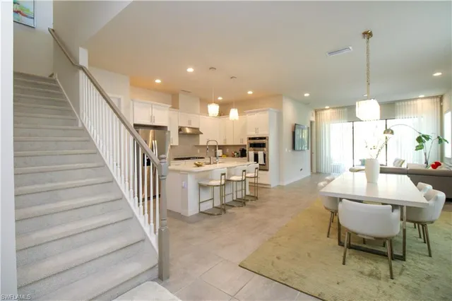 a view of a dining hall with a dining table chairs and white kitchen view