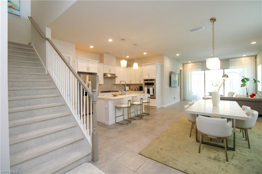 14803 Loggerhead Drive Naples, FL 34120 - Photo 22 of 50 a view of a dining hall with a dining table chairs and white kitchen view