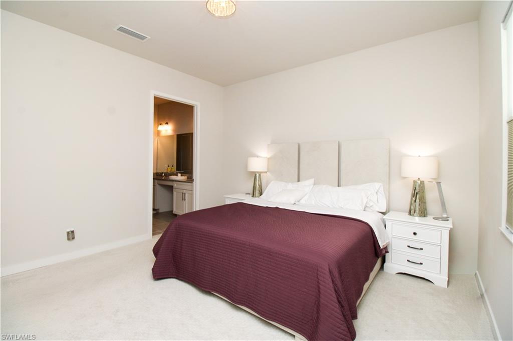 14803 Loggerhead Drive Naples, FL 34120 - Photo 36 of 50 a bedroom with a bed and a lamp