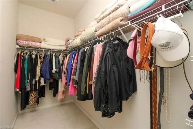 a view of walk in closet with clothes and shoes