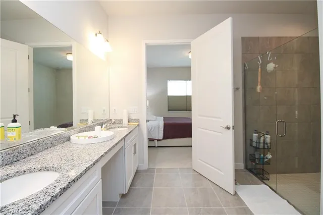 a spacious bathroom with a granite countertop sink mirror and shower