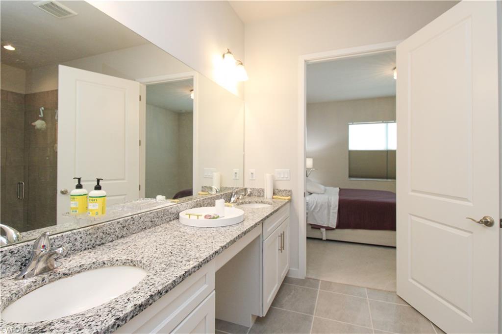 14803 Loggerhead Drive Naples, FL 34120 - Photo 39 of 50 a bathroom with a granite countertop double vanity sink and a mirror