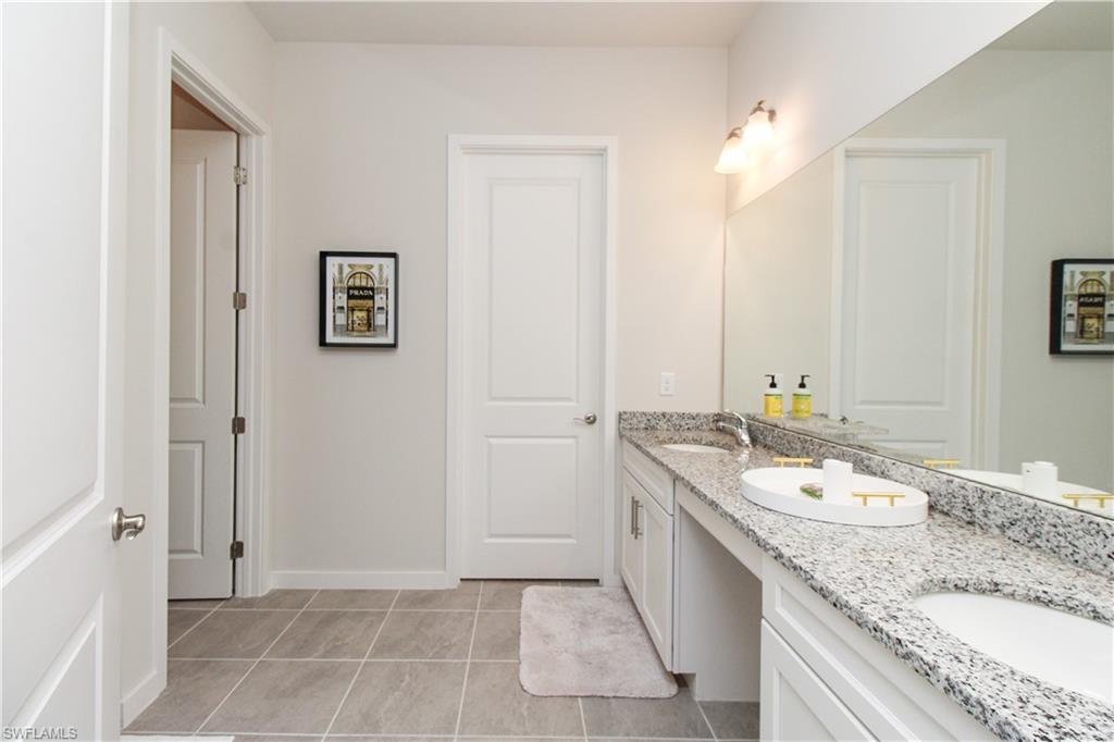 14803 Loggerhead Drive Naples, FL 34120 - Photo 40 of 50 a bathroom with a granite countertop sink and a mirror