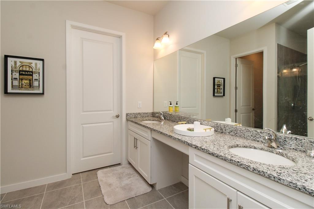 14803 Loggerhead Drive Naples, FL 34120 - Photo 41 of 50 a bathroom with a granite countertop sink and a mirror