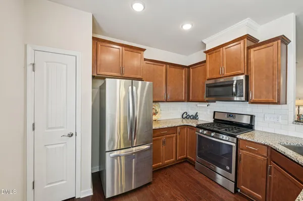 a kitchen with granite countertop a refrigerator stove and microwave
