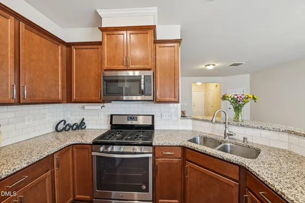 a kitchen with stainless steel appliances granite countertop a sink stove and cabinets