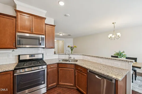 a kitchen with granite countertop a sink stainless steel appliances and cabinets