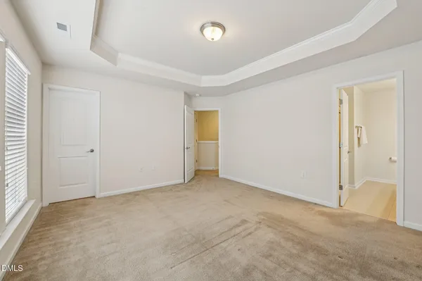 an empty room with closet and windows