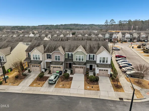 an aerial view of residential houses with outdoor space and parking