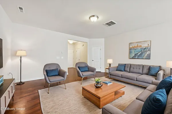 a living room with furniture rug and lamp