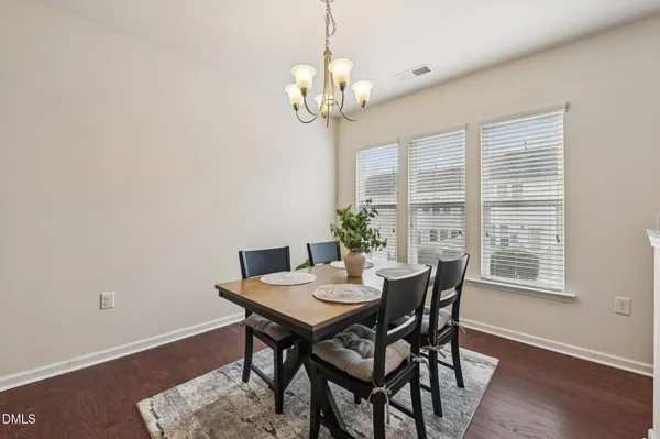 a view of a dining room with furniture a chandelier and wooden floor