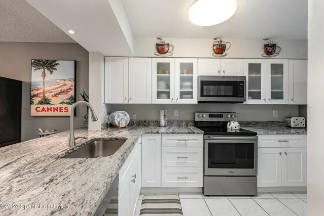 a kitchen with stainless steel appliances granite countertop a sink and a stove top oven