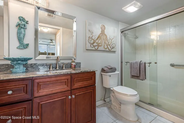 a bathroom with a granite countertop sink a toilet and a mirror