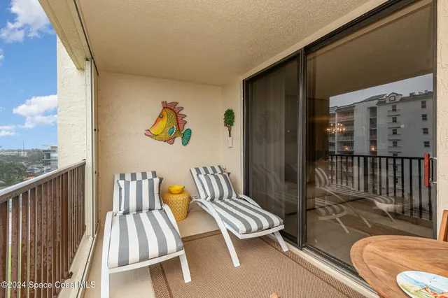 a balcony with chairs and wooden floor