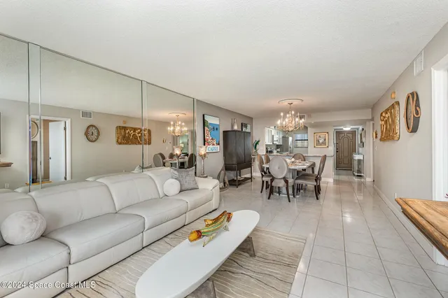 a living room with furniture and a dining table with kitchen view