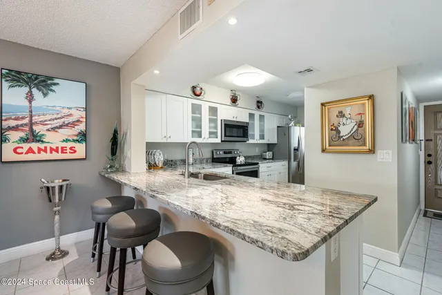 a kitchen with granite countertop kitchen island stainless steel appliances sink stove microwave and cabinets