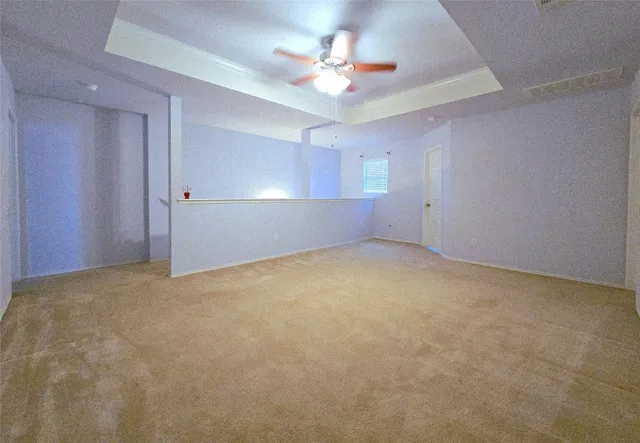 a view of a big room with a ceiling fan and a window