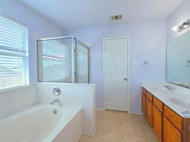 a bathroom with a tub sink and mirror