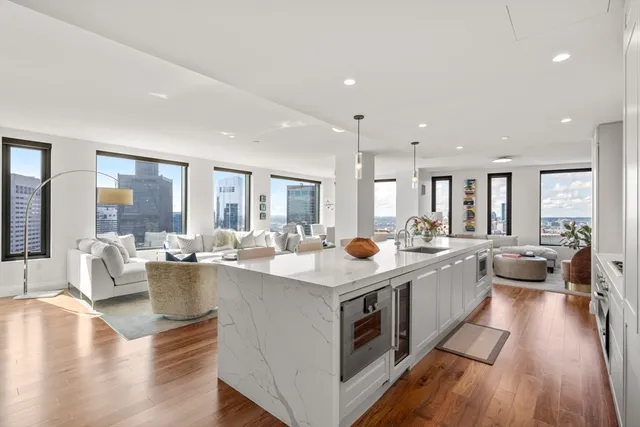 a view of a kitchen counter top space with a sink and living room view