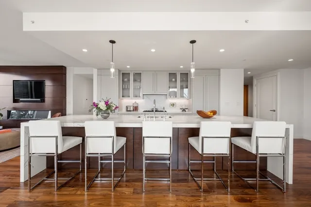a kitchen with kitchen island stainless steel appliances a dining table and chairs