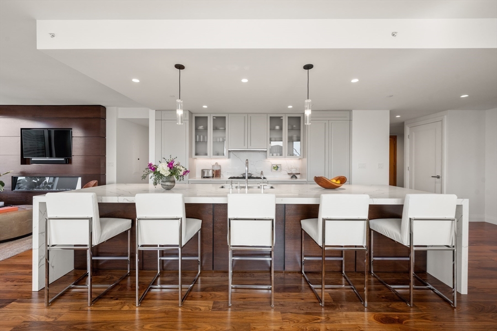 110 Sudbury Street, Unit 4002 Boston, MA 02114 - Photo 14 of 42 a kitchen with kitchen island stainless steel appliances a dining table and chairs