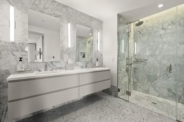 a bathroom with a double vanity sink mirror and shower