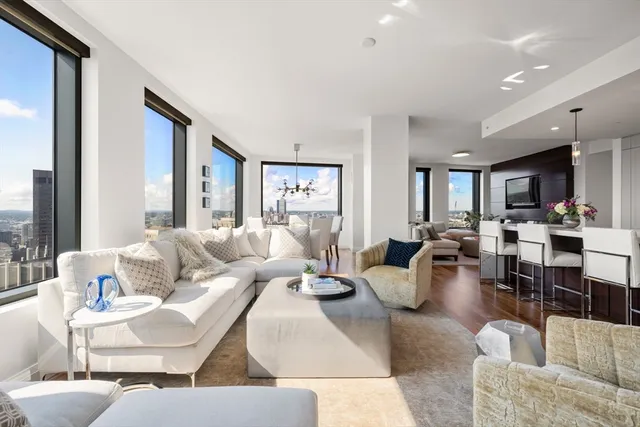 a living room with furniture kitchen view and a large window