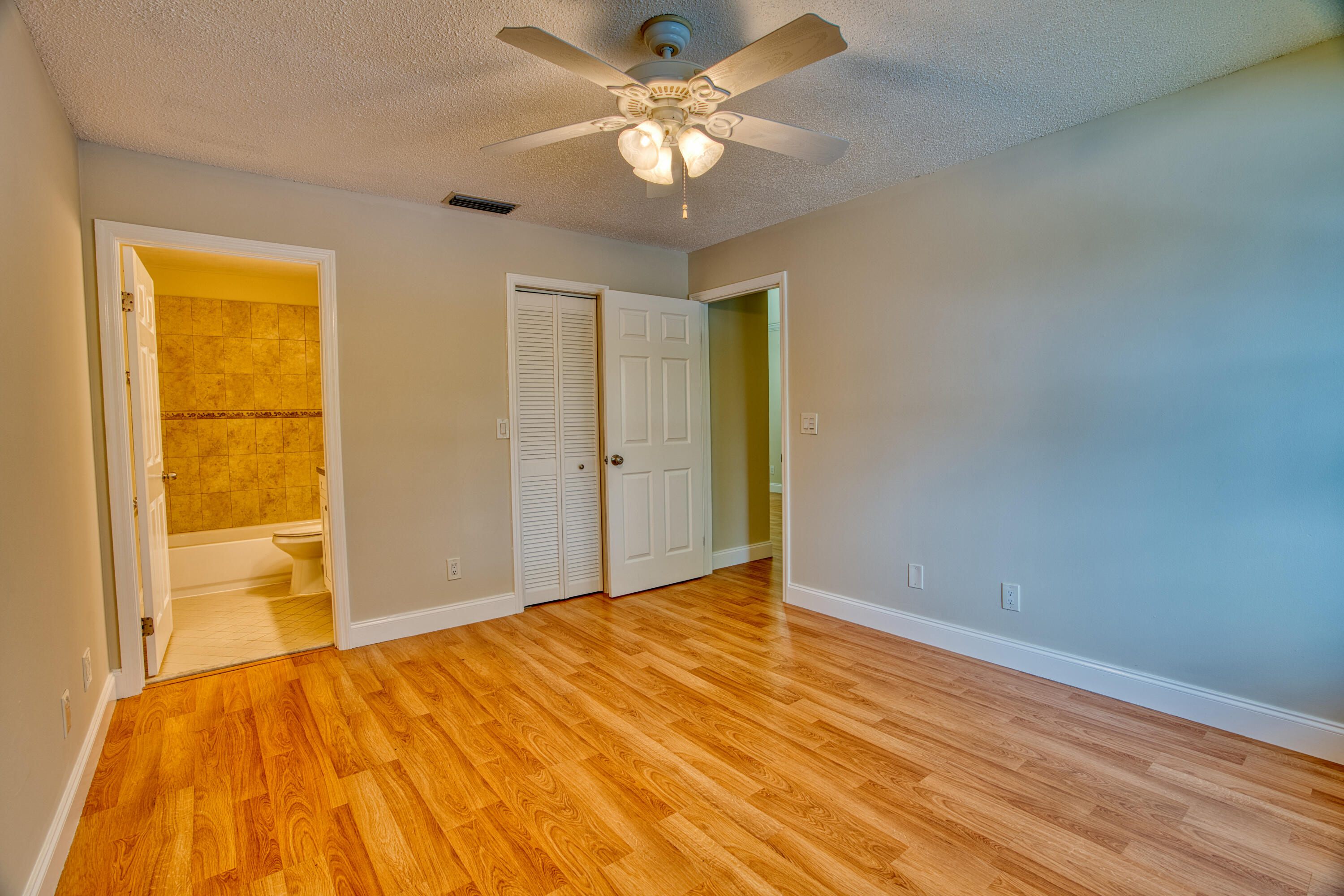 3151 Southeast Aster Lane, Unit 1306 Stuart, FL 34994 - Photo 16 of 27 a view of a big room with wooden floor and a chandelier fan