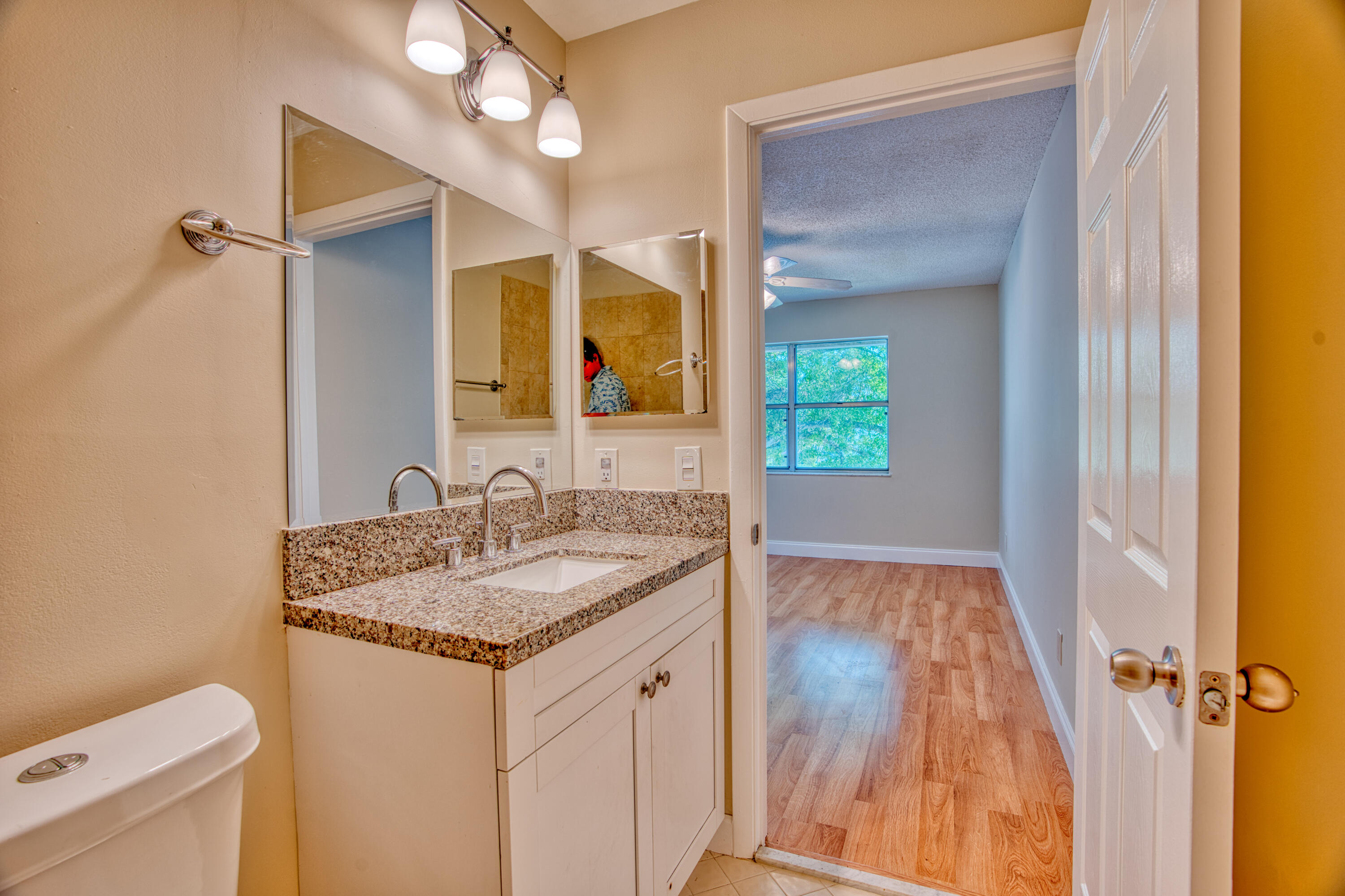 3151 Southeast Aster Lane, Unit 1306 Stuart, FL 34994 - Photo 19 of 27 a bathroom with a granite countertop sink and a mirror