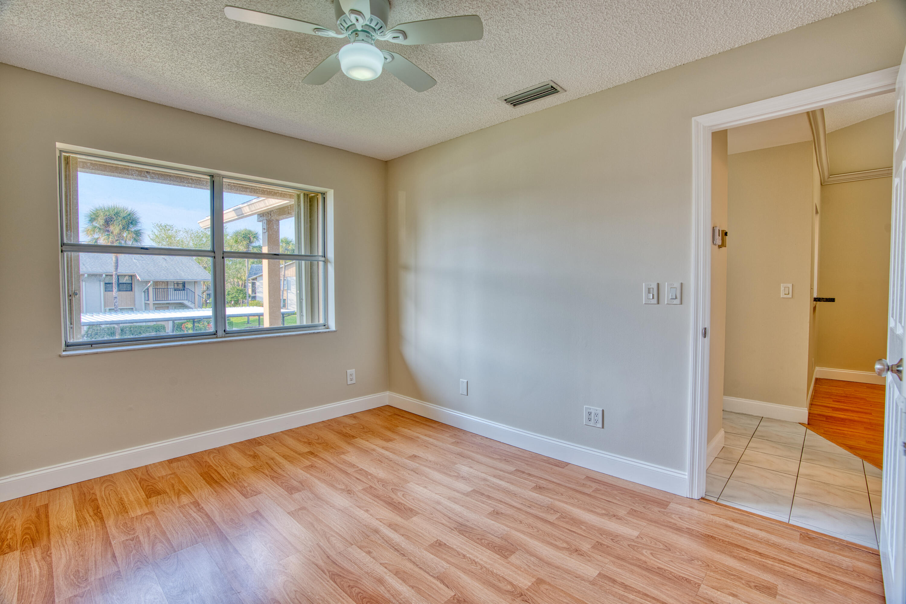 3151 Southeast Aster Lane, Unit 1306 Stuart, FL 34994 - Photo 20 of 27 a view of an empty room with wooden floor and a window