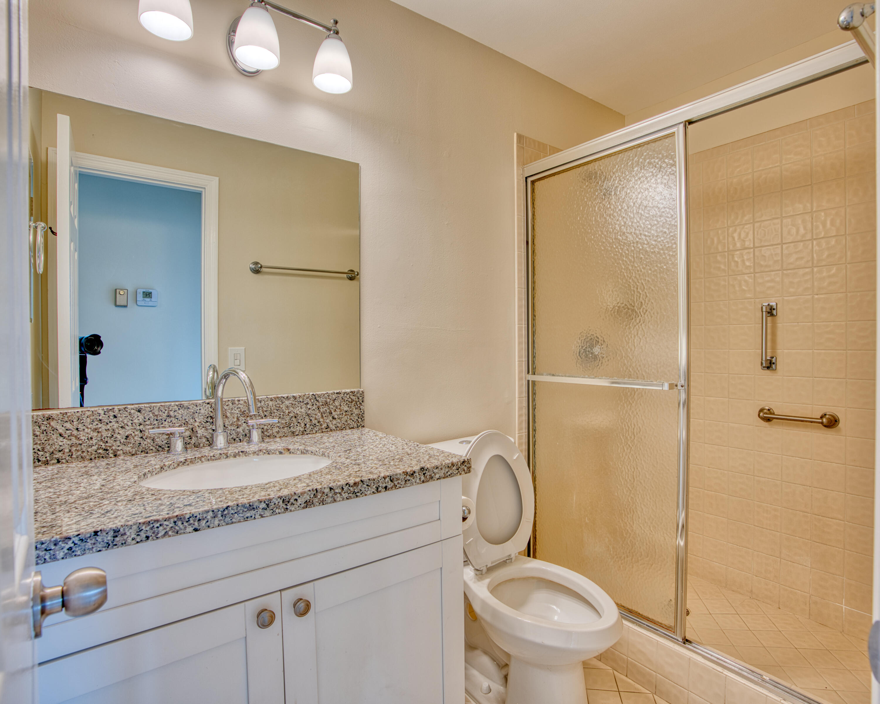 3151 Southeast Aster Lane, Unit 1306 Stuart, FL 34994 - Photo 23 of 27 a bathroom with a granite countertop sink toilet and shower