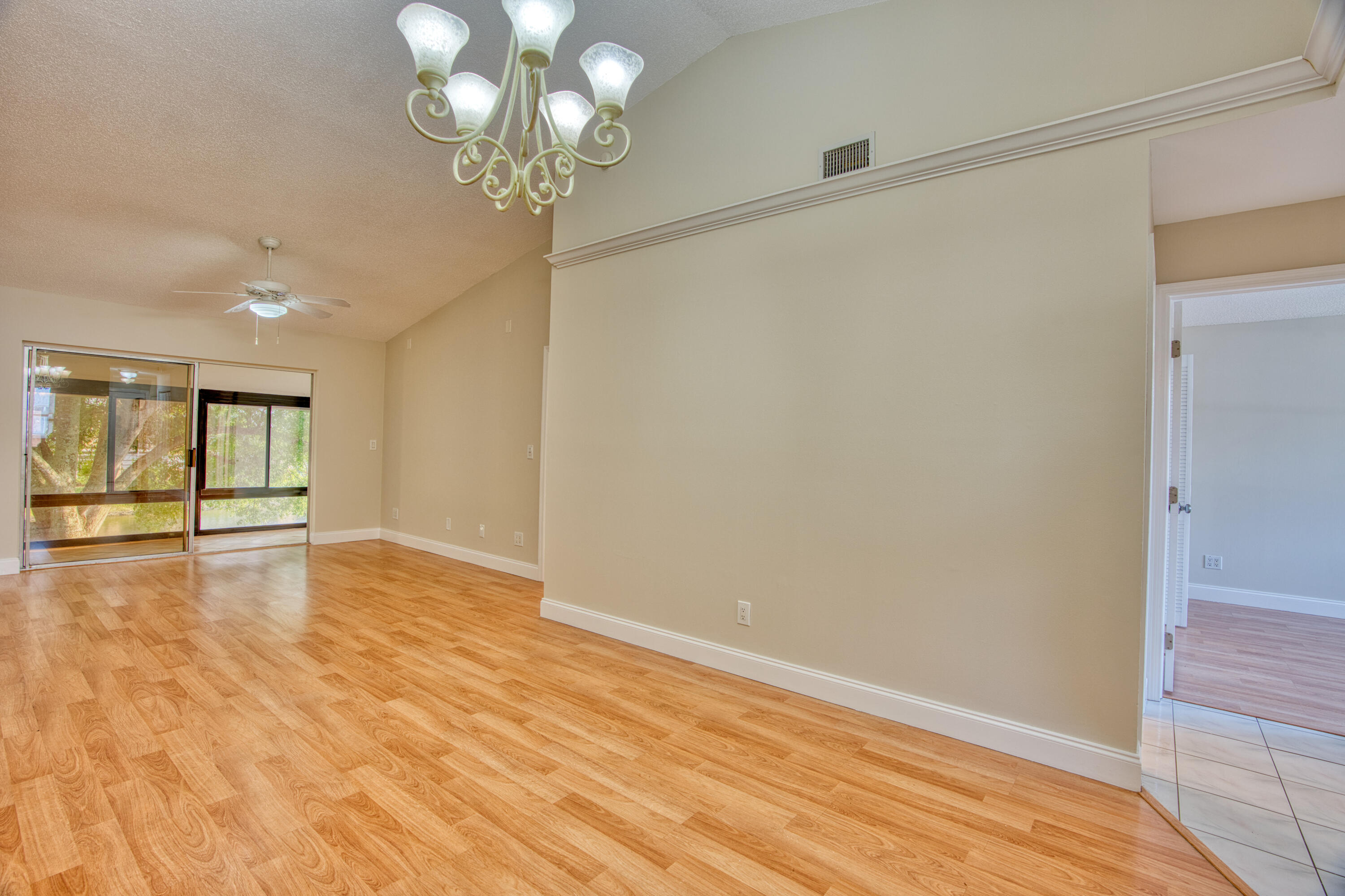 3151 Southeast Aster Lane, Unit 1306 Stuart, FL 34994 - Photo 8 of 27 a view of an empty room with wooden floor and windows
