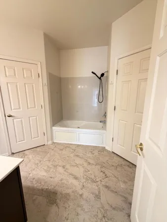 a bathroom with a sink and mirror with bathtub