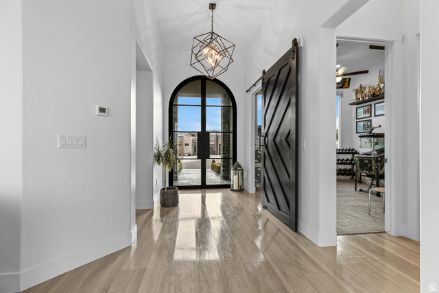 3022 West Sesia Way St. George, UT 84770 - Photo 45 of 52 Entryway with a barn door, light wood-style floors, a high ceiling, and hanging lights