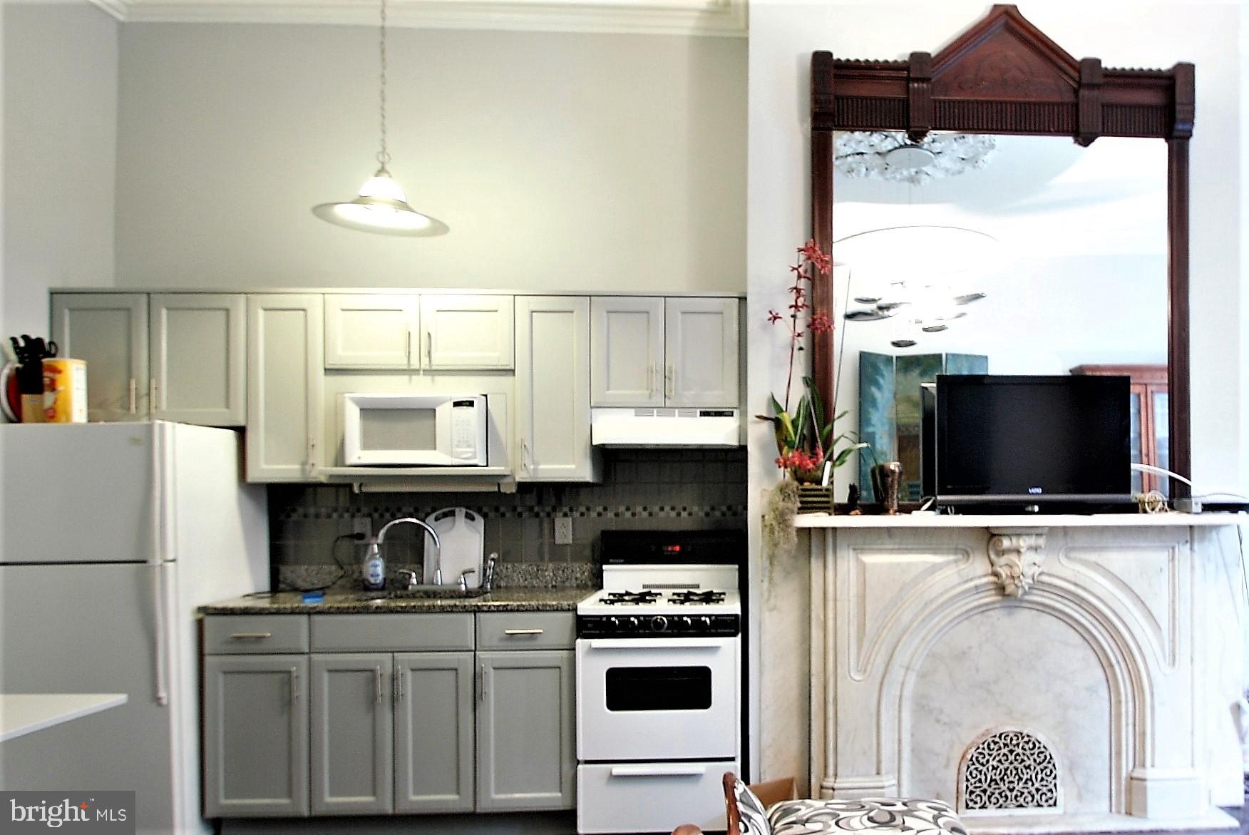 277 South 4th Street, Unit 1F Philadelphia, PA 19106 - Photo 8 of 12 a kitchen with stainless steel appliances a stove a sink and a microwave
