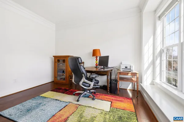 a view of a workspace with furniture and a window