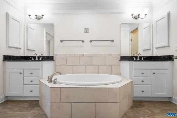 a bathroom with a bathtub and double sink