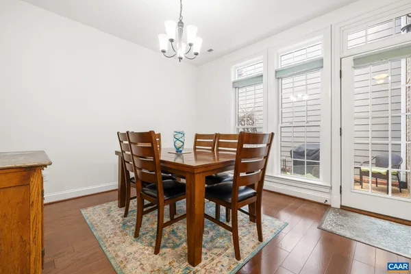 a view of a dining room with furniture wooden floor and a chandelier